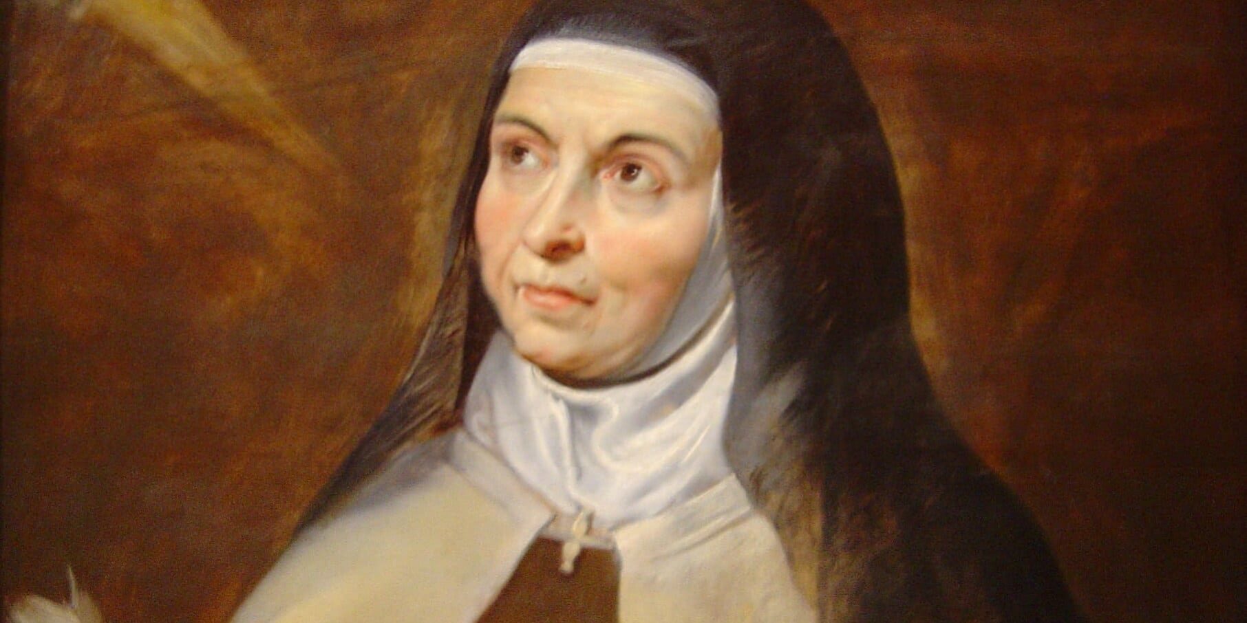 Santa Teresa D'Ávila segurando um livro e uma pena para escrever.