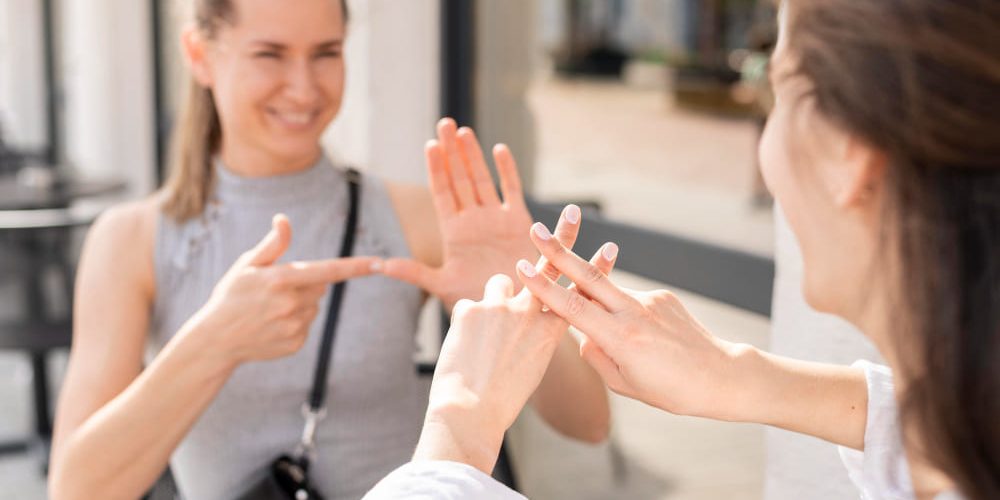 Duas mulheres conversando em língua de sinais.