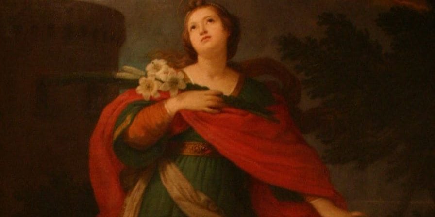 Santa Bárbara segurando buquê de flores e olhando para cima.