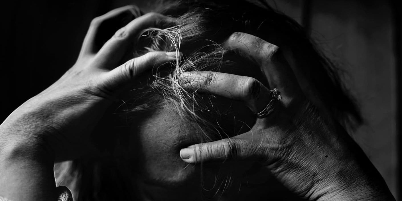 Mulher triste com as mãos na cabeça