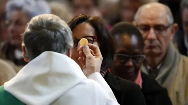 communion-church-priest-pascal-deloche-godong-e1675957643368