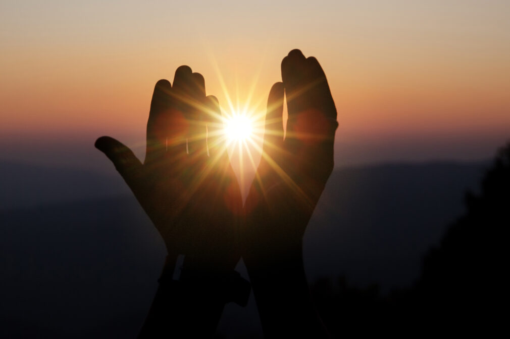 Faith of christian concept: Spiritual prayer hands over sun shin