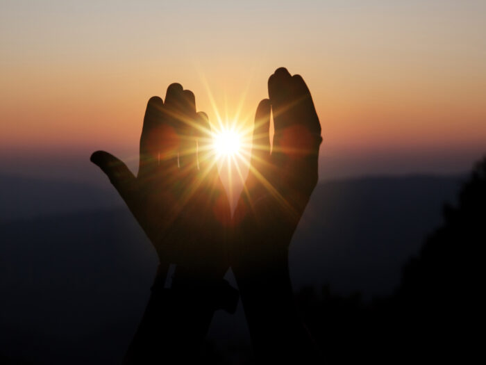 Faith of christian concept: Spiritual prayer hands over sun shin